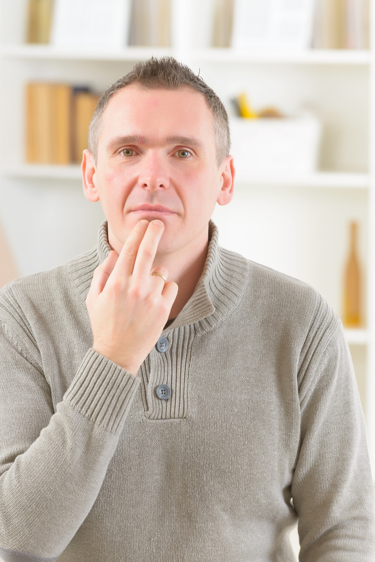 A person tapping with two fingers on their chin